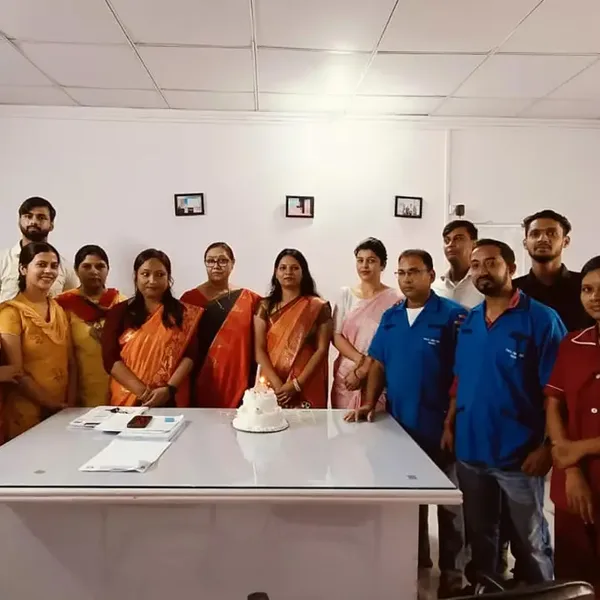 Nursing students and staff gathered around a cake