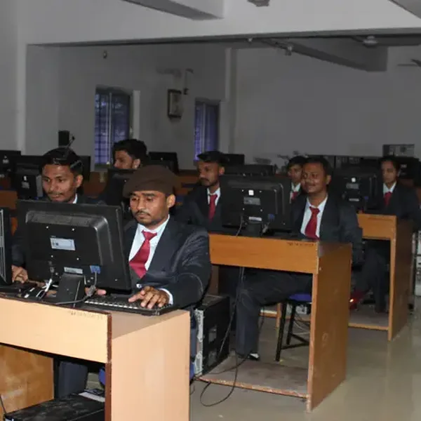 Students in blazers working at computers in a lab